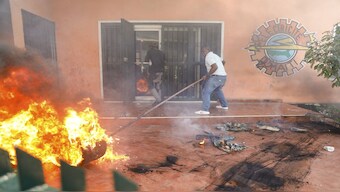 Workers put down a fire set at an office of Haiti's power company during a protest to demand the resignation of the Prime Minister Ariel Henry in Port-au-Prince, Haiti. AP