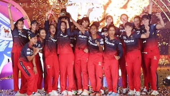 The Royal Challengers Bangalore players celebrate with the trophy after defeating Delhi Capitals to be crowned WPL 2024 champions. Sportzpics
