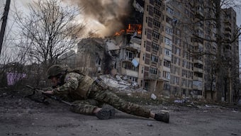 (File) A Ukrainian police officer takes cover in front of a burning building in Avdiivka, Ukraine on 17 March, 2023. AP