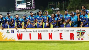 The Sri Lankan players point at their wrists while posing with the trophy won at the end of the T20I series against Bangladesh. Image credit: X/@OfficialSLC