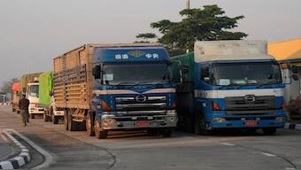 A Myanmar’s truck driver walks by his truck carrying aid before they leave the customs checkpoint near the border with Myanmar, in Mae Sot, Tak province Thailand. AP