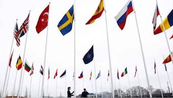 Officials hoisting Sweden's flag along with that of other NATO nations on Monday, AFP. 