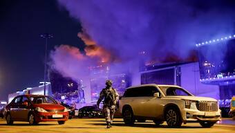 A Russian law enforcement officer walks at a parking area near the burning Crocus City Hall concert venue following a shooting incident, outside Moscow, Russia, March 22, 2024.- Reuters
