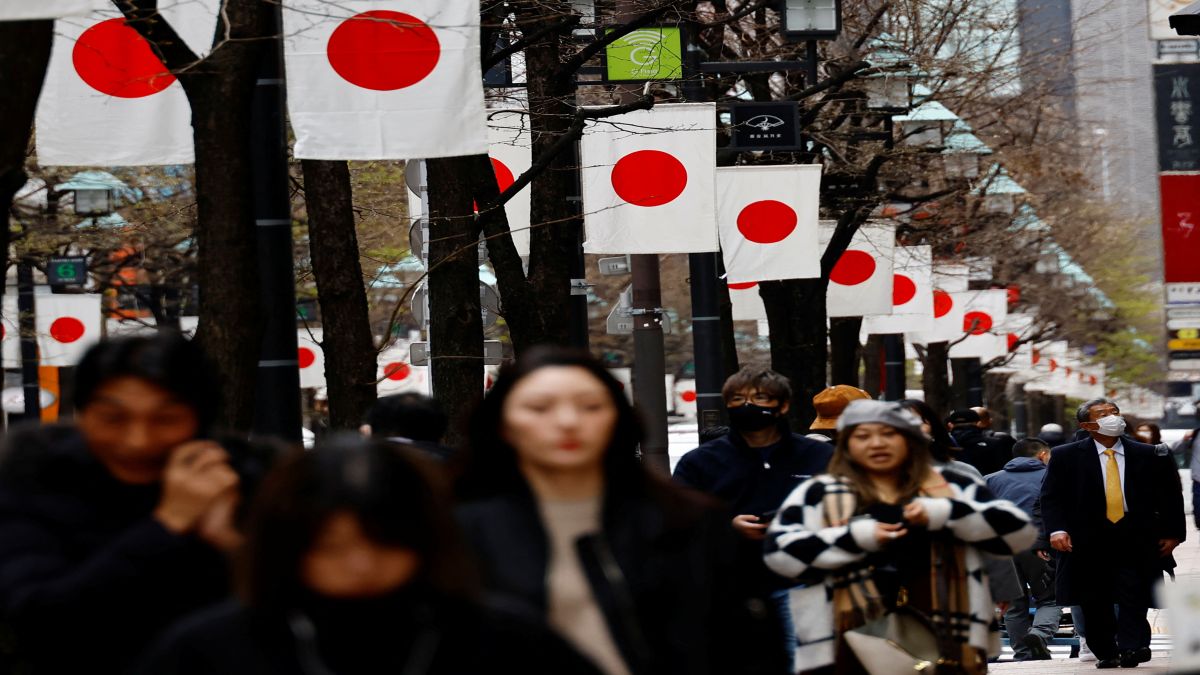 People walk past Japan’s national flags in a shopping district in Tokyo. Japan has ended its negative interest rate policy, marking a historic shift away from an aggressive monetary easing program, implemented years ago to fight chronic deflation. File image/AP People walk past Japan’s national flags in a shopping district in Tokyo. Japan has ended its negative interest rate policy, marking a historic shift away from an aggressive monetary easing program, implemented years ago to fight chronic deflation. File image/AP