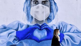 A woman walks past a mural depicting a frontline worker amid the spread of the coronavirus disease (COVID-19) in Dublin, Ireland, January 12, 2022. REUTERS