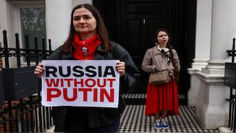 A person holds a placard as people attend a protest against the re-election of incumbent President Vladimir Putin on the final day of the presidential election in Russia, amid Russia's attack on Ukraine, opposite the Russian Embassy, in London, Britain. Reuters