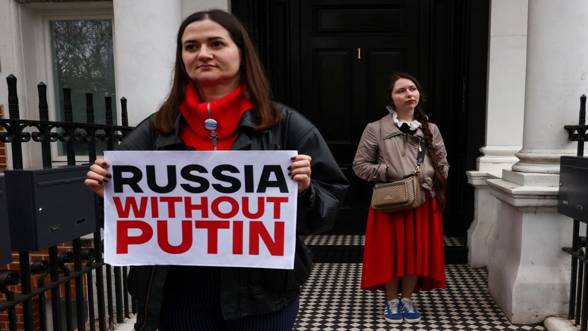 A person holds a placard as people attend a protest against the re-election of incumbent President Vladimir Putin on the final day of the presidential election in Russia, amid Russia's attack on Ukraine, opposite the Russian Embassy, in London, Britain. Reuters A person holds a placard as people attend a protest against the re-election of incumbent President Vladimir Putin on the final day of the presidential election in Russia, amid Russia's attack on Ukraine, opposite the Russian Embassy, in London, Britain. Reuters