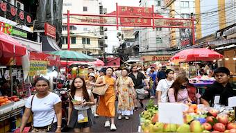 This photo taken on 4 July 2023 shows tourists walking along a street in the Chinatown area of Bangkok. AFP File Photo
