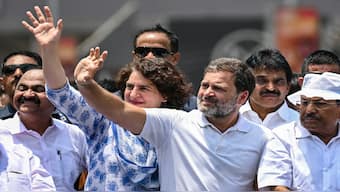 Congress leader Rahul Gandhi and his sister Priyanka Gandhi Vadra greet their supporters during a roadshow, before filing his nomination papers for the upcoming general elections, in Wayanad on 3 April 2024. AFP