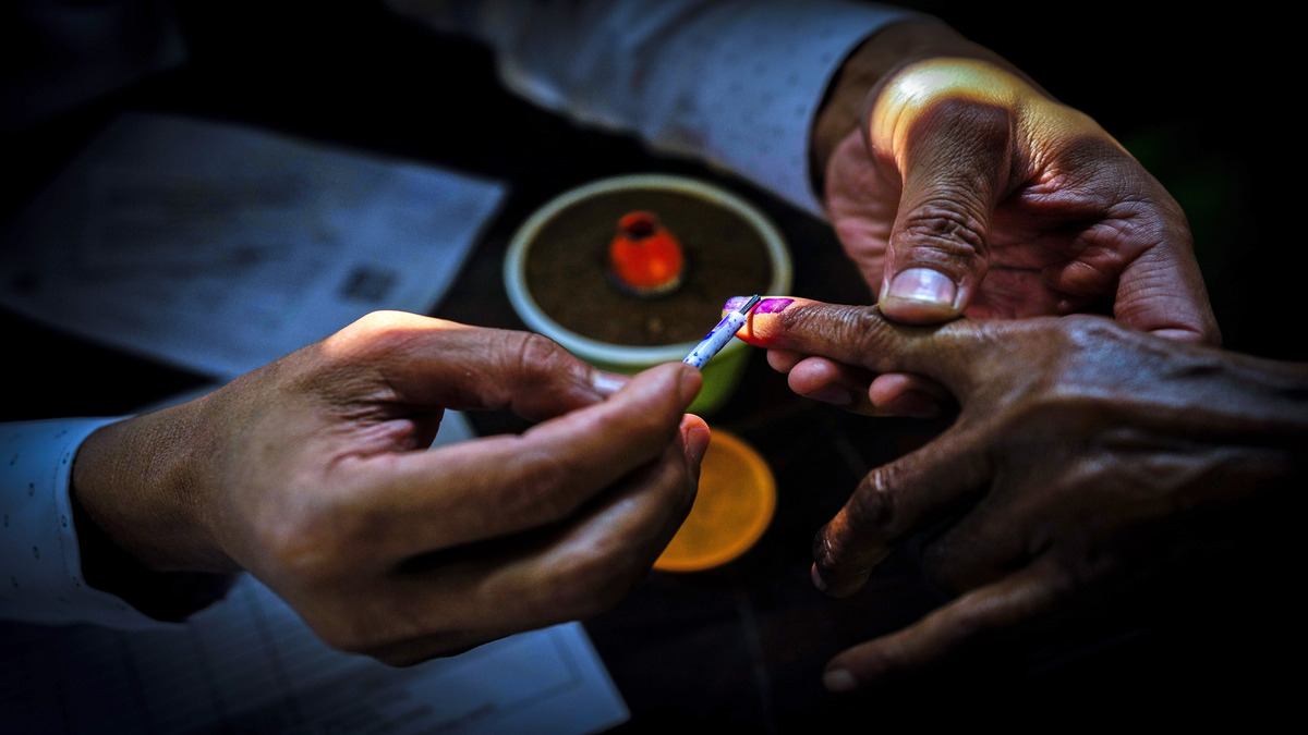 A polling official puts indelible ink mark on the index finger of woman during the second round of voting in the six-week-long national election in Morigaon district, about 77km from Guwahati, on 26 April 2024. AP A polling official puts indelible ink mark on the index finger of woman during the second round of voting in the six-week-long national election in Morigaon district, about 77km from Guwahati, on 26 April 2024. AP