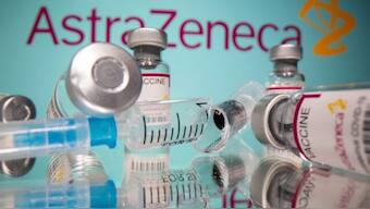 Vials labelled "AstraZeneca COVID-19 Coronavirus Vaccine" and a broken syringe are seen in front of a displayed AstraZeneca logo. REUTERS. 