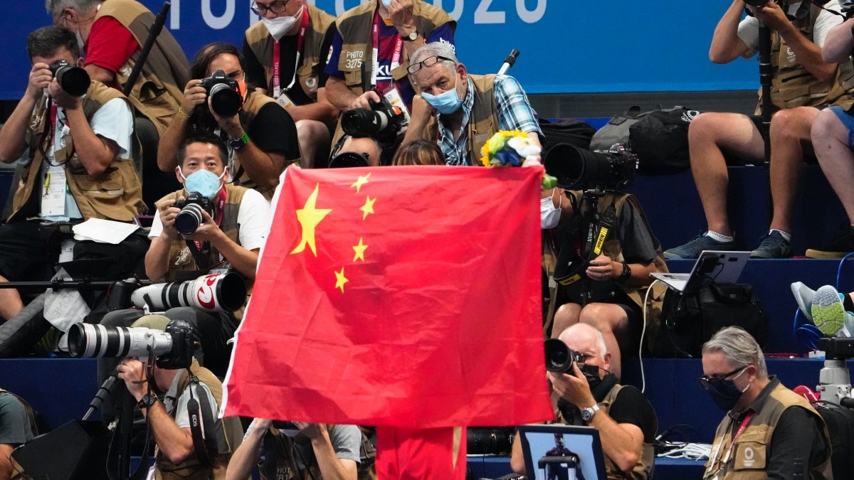 A Chinese flag is unfurled on the podium of a swimming event at the Tokyo Summer Olympics. AP A Chinese flag is unfurled on the podium of a swimming event at the Tokyo Summer Olympics. AP