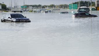 Vehicles sit abandoned in floodwater covering a major road in Dubai, United Arab Emirates, on Wednesday. AP