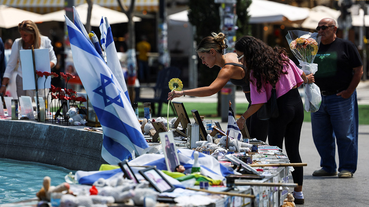 A woman holds a flower as people stand next to memorabilia and pictures of the hostages kidnapped in the deadly 7 October attack on Israel by the Palestinian Islamist group Hamas from Gaza, at Dizengoff Square in Tel Aviv, on 11 April, 2024. Reuters A woman holds a flower as people stand next to memorabilia and pictures of the hostages kidnapped in the deadly 7 October attack on Israel by the Palestinian Islamist group Hamas from Gaza, at Dizengoff Square in Tel Aviv, on 11 April, 2024. Reuters