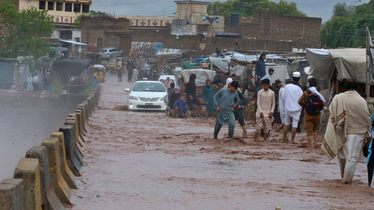 People wade through a flooded bridge on a stream, which is overflowing following heavy rains, on the outskirts of Peshawar, Pakistan, Monday, April 15, 2024. - AP People wade through a flooded bridge on a stream, which is overflowing following heavy rains, on the outskirts of Peshawar, Pakistan, Monday, April 15, 2024. - AP