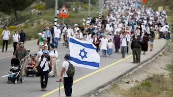 Israeli settlers march to the settler outpost of Evyatar in West Bank. Source: Reuters