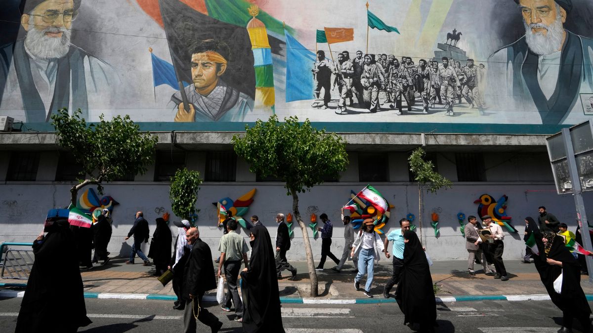 Iranian worshippers walk past a mural showing the late revolutionary founder Ayatollah Khomeini, right, Supreme Leader Ayatollah Ali Khamenei, left, and Basij paramilitary force, in an anti-Israeli gathering after their Friday prayer in Tehran, on 19 April 2024. AP Iranian worshippers walk past a mural showing the late revolutionary founder Ayatollah Khomeini, right, Supreme Leader Ayatollah Ali Khamenei, left, and Basij paramilitary force, in an anti-Israeli gathering after their Friday prayer in Tehran, on 19 April 2024. AP