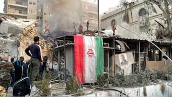 An Iranian flag hangs as smoke rises after what the Iranian media said was an Israeli strike on a building close to the Iranian embassy in Damascus on Monday. Source: Reuters