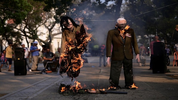 Venezuelans set fire to dummies of Maduro, opposition in Easter rite – Firstpost