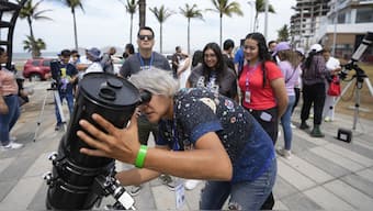 An amateur astronomer prepares her telescope ahead of the total solar eclipse in Mazatlan, Mexico. AP