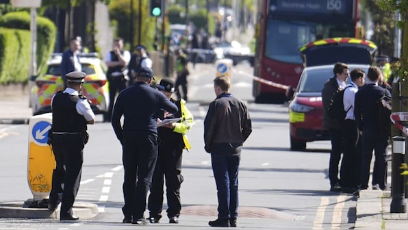 several police officers are standing on the side of the road