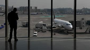 A man takes a picture of a Vistara airline passanger aircraft parked at the Chhatrapati Shivaji Maharaj International Airport in Mumbai. The airline has decided to reduce its capacity by 10 per cent. File photo/Reuters 