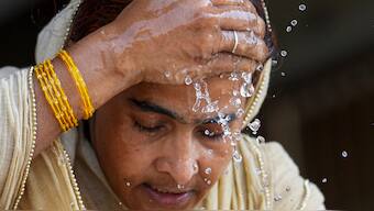 A woman splashes water on her face on a hot summer day amid heatwave, in New Delhi. PTI