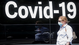 A woman wearing a mask passes by a coronavirus disease mobile testing van in Washington Square Park in New York City, US. Reuters