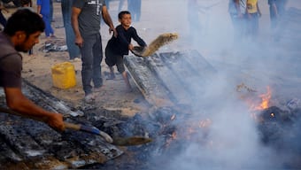 Palestinians put out a fire at the site of an Israeli strike on an area designated for displaced people, in Rafah, in the southern Gaza Strip on 27 May  2024. Reuters