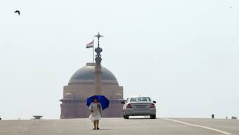 A woman walks under an umbrella as protection from severe heat in New Delhi, India, 18 May 2024. AP File Photo