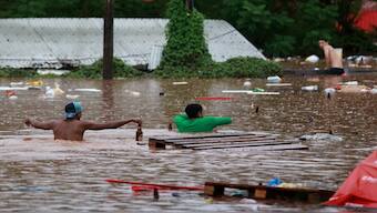 People walk in a flooded area next to the Taquari River during heavy rains in Encantado, Rio Grande do Sul state, Brazil. Reuters