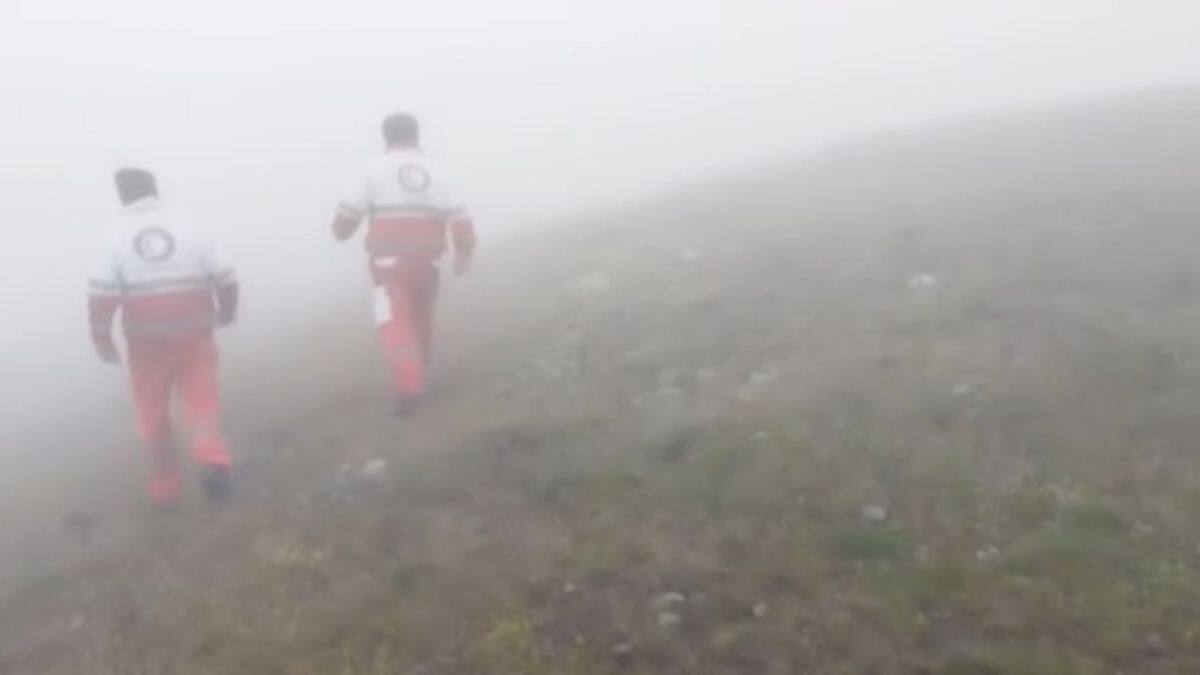 Emergency personnel walk in a foggy area following a crash of a helicopter carrying Iran's President Ebrahim Raisi, in Varzaqan, East Azerbaijan Province, Iran, 19 May, 2024 in this screen grab from a video. Iranian Red Crescent Society via Reuters