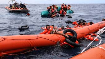 Migrants aboard a rubber boat end up in the water while others cling on to a centifloat before being rescued by a team of the Sea Watch-3, around 35 miles away from Libya. AP File