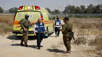 Israeli soldiers and medics walk near an ambulance after Palestinian Islamist group Hamas claimed responsibility for an attack on Kerem Shalom crossing, near Israel's border with Gaza in southern Israel, on 5 May, 2024. Reuters