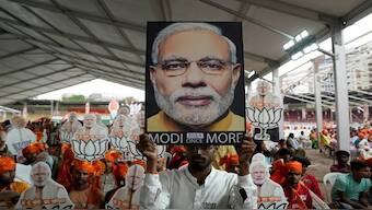 BJP supporters carry portraits of Prime Minister Narendra Modi as they attend a public rally, Hyderabad, India. [Mahesh Kumar A/AP]