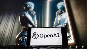 (File) The OpenAI logo is displayed on a cell phone with an image on a computer monitor generated by ChatGPT's Dall-E text-to-image model, on 8 December, 2023, in Boston. AP