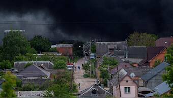 People walk on a street while smoke rises after a Russian attack in Kharkiv, Ukraine, Friday, May 17, 2024. - File AP