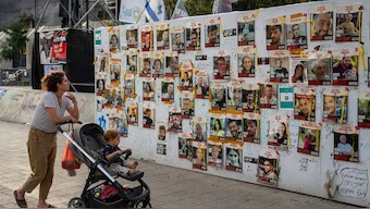 Passersby observe the photos of hostages held in the Gaza Strip that are plastered to the walls of a plaza known as Hostages Square in Tel Aviv, Israel, 17 May, 2024. AP