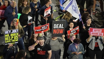 Relatives and supporters of hostages taken captive by Hamas in Gaza during the 7 October attacks, hold placards and wave national flags during a demonstration calling for their release, in the Israeli coastal city of Tel Aviv. AFP