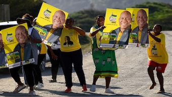 Supporters of the ANC hold placards bearing the face of South Africa's and ANC president Cyril Ramaphosa at Port St. Johns, in the eastern Cape province of South Africa. Early trends from polling show that the ANC having  42-43 per cent of the votes. File image/Reuters