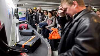 Passengers arriving on a delayed United Airlines flight from Chicago wait for their luggage at a baggage carousel at LaGuardia Airport in New York, 19 December 2008. Reuters/Representative Image