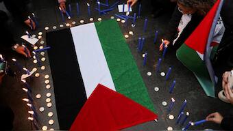 Members of the Palestinian community living in Chile and supporters light candles around a Palestinian flag after attending a mass at Santiago's cathedral to mark the 76th anniversary of the Nakba, amid the ongoing conflict between Israel and Hamas, in Santiago, Chile, June 9, 2024. REUTERS/Sofia Yanjari. 