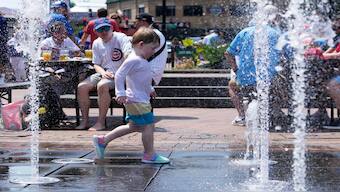 A kid cools off at Gallagher Way park fountain during hot weather in Chicago. AP