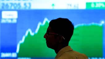 A man looks at a screen displaying news of markets update inside the Bombay Stock Exchange (BSE) building in Mumbai. Source: FILE/ REUTERS 