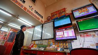 A customer looks at screens showing lottery information at a lottery ticket store in Shanghai, 29 December, 2013. File Image/Reuters