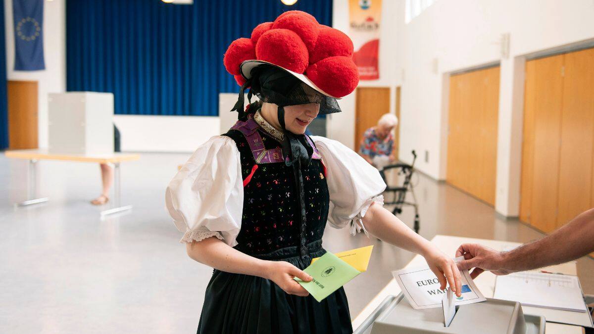 A voter, dressed in traditional Black Forest attire. with red Bollenhut hat, casts her ballot for the European Parliament elections at the polling station in Gutach im Breisgau, Germany, 9 June, 2024. AP