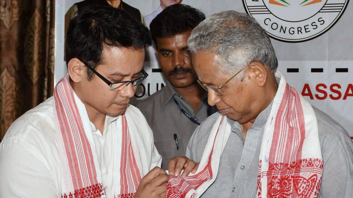 (File) Gaurav Gogoi ties a badge to former chief minister of Assam Tarun Gogoi during an event, in Guwahati. PTI