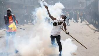 A protester lobs back a teargas canister at police during a nationwide strike to protest against tax hikes and the Finance Bill 2024 in downtown Nairobi, on June 25, 2024. Source: AFP. 