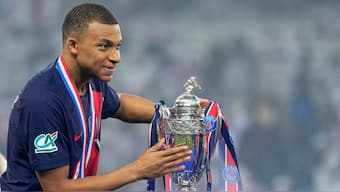 Kylian Mbappe poses with the winner's trophy after helping Paris Saint-Germain win the French Cup in his final appearance for the club. AP