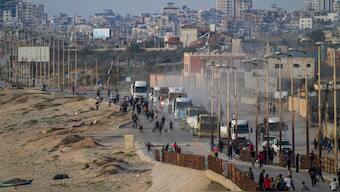 FILE - Palestinians storm rucks loaded with humanitarian aid brought in through a new U.S.-built pier, in the central Gaza Strip, Saturday, May 18, 2024.-AP